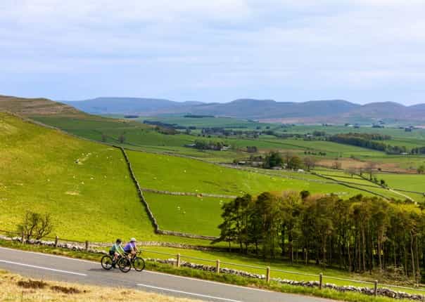 Two road cyclists riding in the Eden District of Cumbria on a cycling tour
