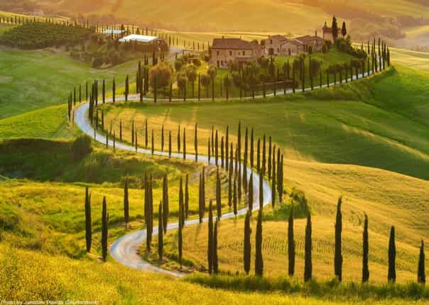Scenic winding road and cypress trees in Tuscan countryside