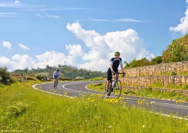 Two road cyclists riding along a smooth road in Southern Italy on a guided cycling tour