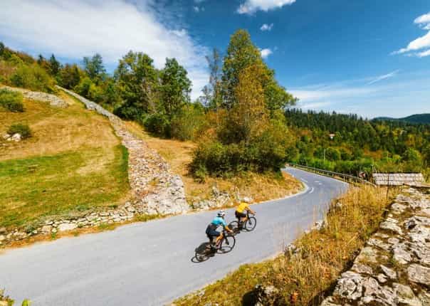 Road cyclists riding a winding mountain road on a guided cycling tour