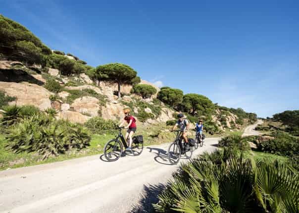 Three cyclists on a cycling holiday riding along a scenic coastal path in Andalucia
