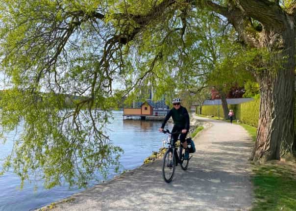 Male cyclist riding alongside waterways and canal in Sweden