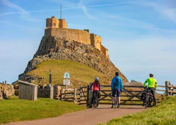 Cyclists at Lindisfarne Castle in Holy Island, England