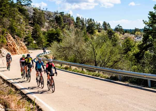 Group of road cyclists riding a scenic road in Spain on a guided tour.png