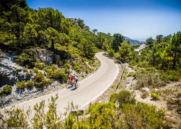 Two road cyclists riding a scenic mountain road in Southern Spain