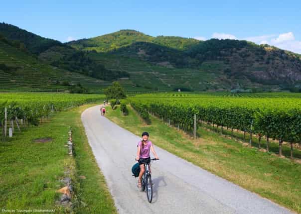 Happy female cyclist riding along the Danube Cycle Path in the Wachau region of Austria