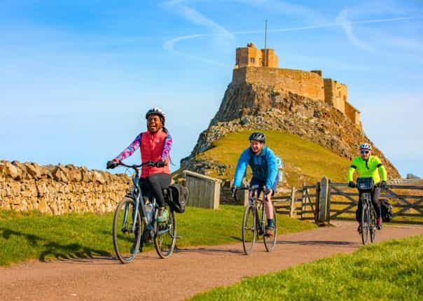 Cyclists riding at Holy Island on the Coast and Castles cycling holiday.png