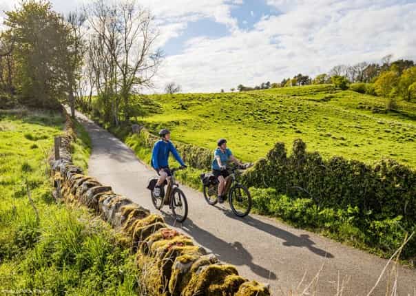 Two cyclists riding the Hadrian's Cycleway route on a cycling tour