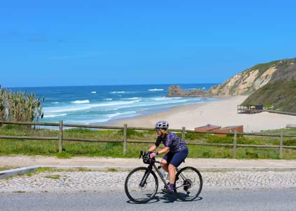 Female cycling along the coast of Portugal on a guided cycling tour