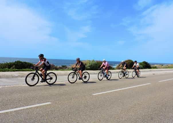Group of cyclists riding along a coastal road in Portugal on a guided cycling tour