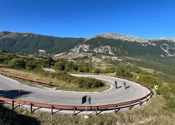 Road cyclists on a hairpin turn on a mountain road in Italy