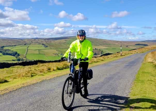 Happy female cyclist riding the C2C coast to coast route.png