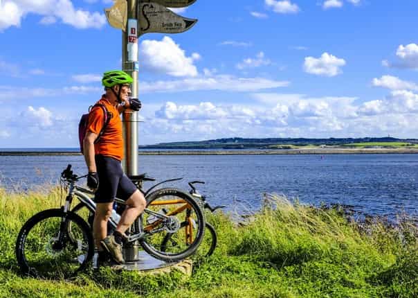 Cyclist overlooking the sea on the coast to coast cycle route